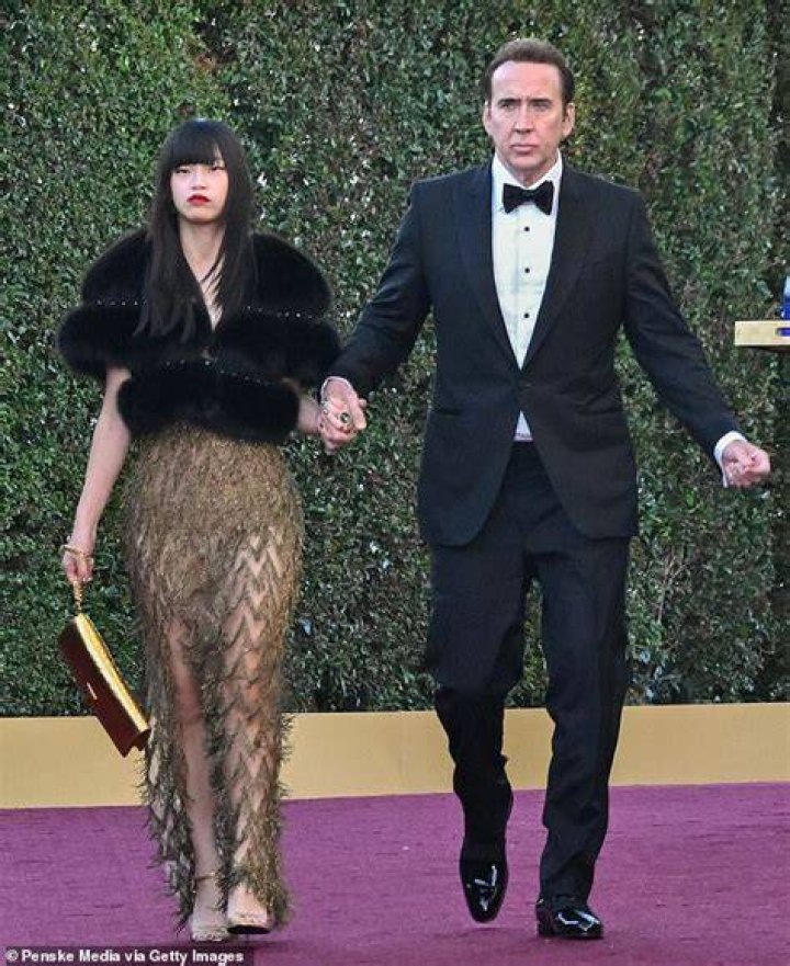 Nicolas Cage’s Wife Covers Baby Bump In Flowy Dress As They Hold Hands On Red Carpet